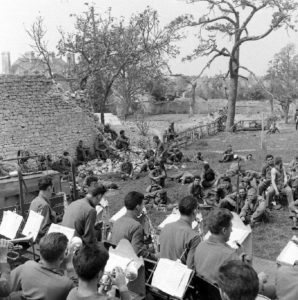 Concert organisé pour les pensionnaires de l'infirmerie tenue par le 308th Medical Battalion, 83rd (US) Infantry Division au numéro 45 rue Holgate à Carentan, dans l'hôtel Durand de la Borderie-Énouf. Photo : US National Archives