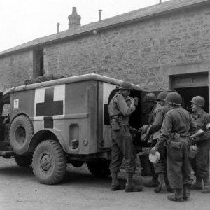 Une ambulance Dodge WC 54 devant l'infirmerie tenue par le 308th Medical Battalion, 83rd (US) Infantry Division au numéro 45 rue Holgate à Carentan, dans l'hôtel Durand de la Borderie-Énouf. Photo : US National Archives