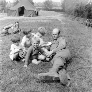 Des enfants rendent visite aux pensionnaires américains de l'infirmerie tenue par le 308th Medical Battalion, 83rd (US) Infantry Division au numéro 45 rue Holgate à Carentan, dans l'hôtel Durand de la Borderie-Énouf. Photo : US National Archives