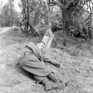 Un pensionnaire américain de l'infirmerie tenue par le 308th Medical Battalion, 83rd (US) Infantry Division au numéro 45 rue Holgate à Carentan, dans l'hôtel Durand de la Borderie-Énouf, se repose dans le parc de la propriété. Photo : US National Archives