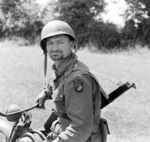 Juin 1944 : un parachutiste-estafette au guidon de sa 1943 Simplex, au campement provisoire de l’état-major de la 101st (US) Airborne Division, situé au bassin à flot à Carentan. Photo : US National Archives