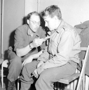 Auscultation d'un pensionnaire américain de l'infirmerie tenue par le 308th Medical Battalion, 83rd (US) Infantry Division au numéro 45 rue Holgate à Carentan, dans l'hôtel Durand de la Borderie-Énouf. Photo : US National Archives