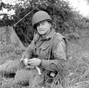 Juin 1944 : un parachutiste se restaure au campement provisoire de l’état-major de la 101st (US) Airborne Division, situé au bassin à flot à Carentan. Photo : US National Archives