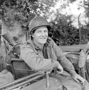 Juin 1944 : un parachutiste à bord d'une Jeep au campement provisoire de l’état-major de la 101st (US) Airborne Division, situé au bassin à flot à Carentan. Photo : US National Archives