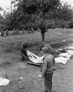 12 juillet 1944 : mise en bière de corps de soldats allemands au cimetière militaire d'Orglandes, par les prisonniers allemands sous contrôle de la police militaire américaine. Photo : US National Archives