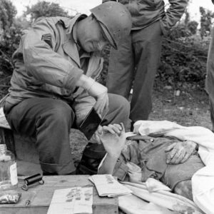 12 juillet 1944 : préparation à la mise en bière de soldats allemands et récupération des empreintes des défunts par des Américains appartenant à la 4th Platoon, 603rd Quartermaster Graves Registration Company (First US Army) au cimetière militaire d'Orglandes. Photo : US National Archives
