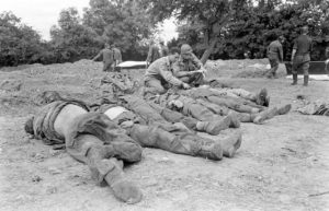 12 juillet 1944 : préparation à la mise en bière de soldats allemands par des Américains appartenant à la 4th Platoon, 603rd Quartermaster Graves Registration Company (First US Army) au cimetière militaire d'Orglandes. Photo : US National Archives