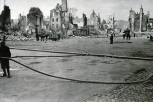 Pompier en action place Thiers (devenue place Mitterrand) à Lisieux après les bombardements de juin 1944. Photo : DR