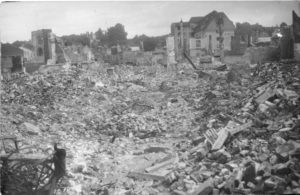 Ruines du centre-ville de Lisieux après les bombardements de juin 1944. L'hôtel de l'Espérance est visible à droite tout comme le clocher de l'église Saint-Jacques à gauche. Photo : DR