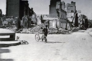 Un normand place Fournet à Lisieux au milieu des décombres après les bombardements de juin 1944. Photo : DR