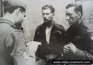 Juin 1944 : Gérald De Baeker, volontaire français dans les S.S., interroge deux prisonniers canadiens. Photo : Bundesarchiv