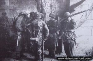 Des soldats S.S. en tenue camouflée dans l'enceinte de l'Abbaye d'Ardenne. Photo : Bundesarchiv
