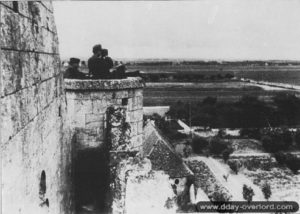 Des observateurs allemands installés dans la tourelle au sud-ouest de l'abbatiale regardent en direction de la RN 13 et de Carpiquet. Photo : Bundesarchiv