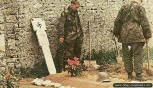 9 juin 1944 : les hommes de la 15. Aufklärungskompanie du S.S. Pz.Gren.Rgt 25. de la 12. SS-Panzer-Division Hitlerjugend enterrent leurs morts apès les combats contre les Canadiens. Ici, la tombe du SS-Oscha. Helmut Belke tué dans la nuit du 8 au 9 juin 1944. Photo : Bundesarchiv