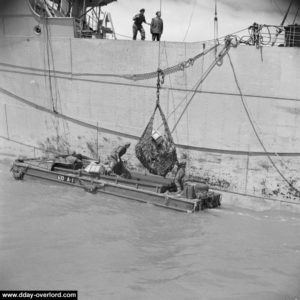 Un DUKW est chargé par un cargo de matériel à débarquer. Photo IWM