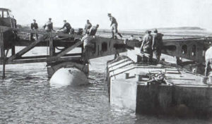 Fixation des différents éléments d’une des jetées du Mulberry B d'Arromanches. Photo IWM