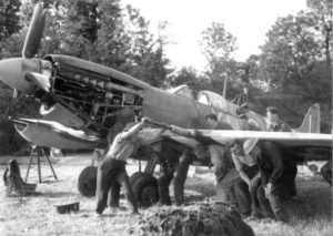 Des mécaniciens et équipages anglais remettent en condition un Spitfire sur un aérodrome de Normandie. Photo : IWM