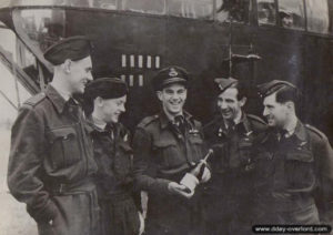 L’équipage du "Q for Queenie", 297th Squadron, ouvrant leur première bouteille de la libération devant le bombardier Lancaster. De gauche à droite : Brian Easton, Vic Clements, Roy Shortman, George Jenkins et Jim Peppit. Photo : IWM