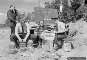 Des contrôleurs aériens anglais travaillant à leur poste de travail rudimentaire installé sur l’aérodrome ALG B-02 de Bazenville. Photo : IWM