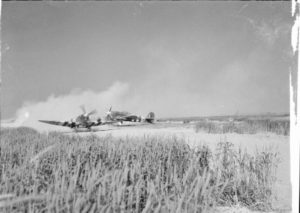 Sur l’aérodrome ALG B-02 de Bazenville, un Spitfire Mk IX progresse sur la piste devant un Typhoon Mk Ib appartenant au 181 Squadron. Photo : IWM