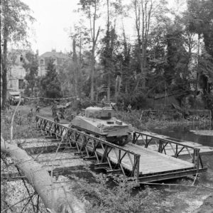 Dans la matinée du 19 juillet 1944 à Caen, un char M4 Sherman de la 2nd (CA) Armoured Brigade traverse l'Orne sur un pont de bateaux Bailey. Photo : Ralph Morse pour LIFE Magazine