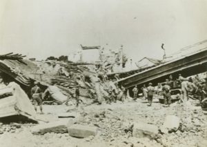 22 juillet 1944 : le pont ferroviaire du quartier de Vaucelles à Caen, détruit, surplombait la rue de la gare. Des sapeurs canadiens débutent la lourde tâche de dégager les décombres. Photo : Library and Archives Canada