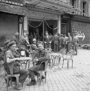 22 juillet 1944 : à l'intérieur de l'ancienne boutique d'un fleuriste, située boulevard Saint-Pierre (aujourd'hui boulevard des Alliés) à Caen, une cantine a été installée par les NAAFI (Navy, Army and Air Forces Institutes) au profit des militaires alliés. Photo : IWM B 7895