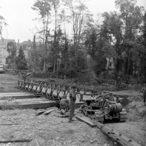 19 juillet 1944 à Caen : un bulldozer de la 1st Field Park Company aux abords du pont Bailey sur bateaux au-dessus de l'Orne, construit par les Canadiens de la 11th Field Company, Royal Canadian Engineer (2nd CA Infantry Division). Photo : Ralph Morse pour LIFE Magazine