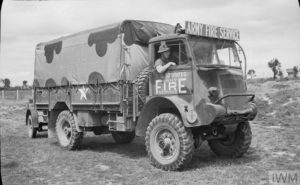 Un camion Bedford QL 3 ton britannique en dotation au sein de la 104 Fire Fighting Company (Army Fire Service), stationnée à Caen. Cette unité avait pour mission de protéger des flammes les sites sensibles militaires (dépôts de munitions, lieux de vie et de stockage) ainsi que les biens civils dans les communes libérées. Photo : IWM B 8120