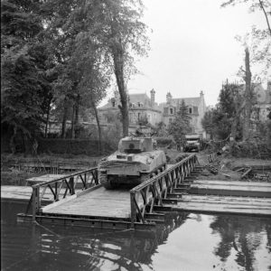 Dans la matinée du 19 juillet 1944 à Caen, un char M4 Sherman de la 2nd (CA) Armoured Brigade traverse l'Orne sur un pont de bateaux Bailey. Photo : Ralph Morse pour LIFE Magazine