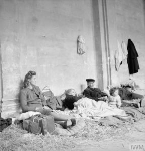 Une famille de réfugiés de la ville de Caen a trouvé un abri temporaire dans le cloître de la cathédrale. Photo : IWM B 7101