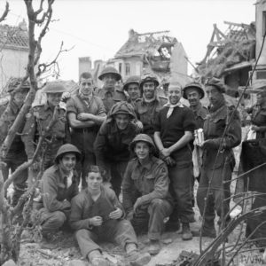 10 juillet 1944 : un groupe de soldats canadiens appartenant à la 3rd (CA) Infantry Division prennent la pose pour le photographe, dans les ruines du nord de la ville de Caen. Photo : IWM B 6887