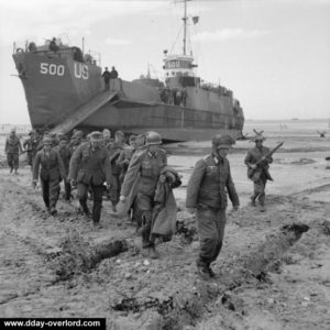 7 juin 1944 : des prisonniers allemands sont déplacés vers un point de regroupement sur Gold Beach. En arrière plan, le LCI 500 de l'US Navy. Photo : IWM