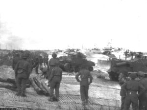 Débarquement d'un char Sherman et d'un Bulldozer à Gold Beach. En arrière-plan, des LCI(l) débarquent les personnels sur la plage. Photo : IWM