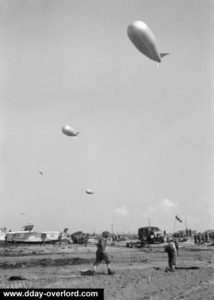 17 juin 1944 : ballons captifs dans le ciel de Gold Beach, secteur King. Ces ballons étaient utilisés dans le cadre de la défense antiaérienne. Photo : IWM