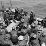 Le 6 juin 1944 à Juno Beach, le lieutenant Jack Beveridge, blessé par l'explosion d'une mine, est évacué à bord du H.M.C.S. Prince David au large de Bernières-sur-Mer. Photo : Archives Canada