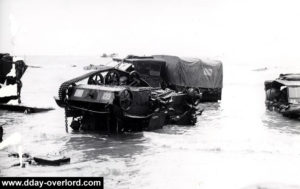 Des véhicules abandonnés sur la plage de Juno, en particulier un Universal Carrier sur le toit. Photo : Archives Canada