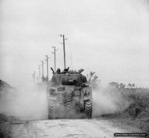 9 juillet 1944 : un char Sherman Firefly de la 27th Armoured Brigade progresse en direction de Lébisey. Photo : IWM
