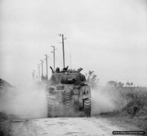 9 juillet 1944 : un char Sherman Firefly de la 27th Armoured Brigade progresse en direction de Lébisey. Photo : IWM