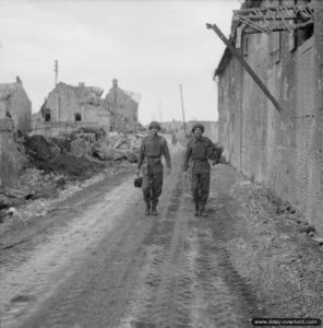 Les sergents Ernest Walter et A. C. Gross de la No 5 Army Film and Photographic Unit marchent dans Lébisey. Photo : IWM