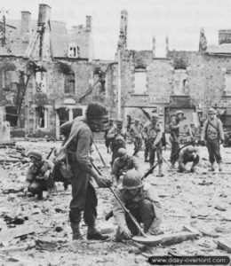 Des sapeurs appartenant à la 79th (US) Infantry Division employés à déminer les axes au milieu des ruines de la commune de Lessay, libérée le 27 juillet 1944. Photo : US National Archives