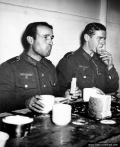 Des prisonniers allemands prennent leur repas pendant la traversée vers l'Angleterre. Photo : US National Archives