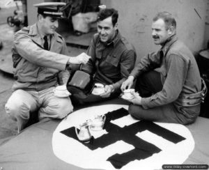 Des officiers des garde-côtes (de gauche à droite Louis A. Schulte, Lloyd B. Patch et Carl K. Buechner) prennent le thé avec leur nouvelle nappe. Photo : US National Archives