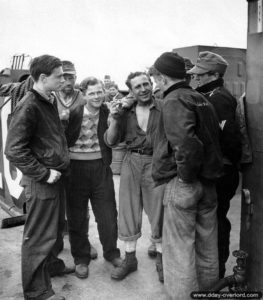 Des prisonniers allemands, avec déjà des habits civils, discutent avec des marins américains. Photo : US National Archives