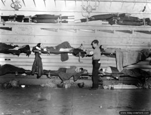 Des blessés installés le long du pont des chars à bord d'un LST. Photo : US National Archives