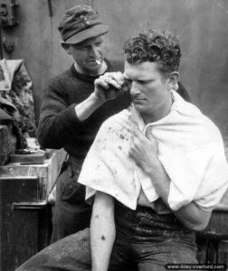 A German gets his hair cut while crossing the Channel to England. Photo: US National Archives