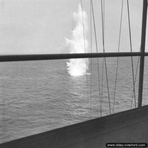 On June 25, 1944, off Cherbourg, a shell fired by German batteries falls near the USS Texas. Photo: US National Archives