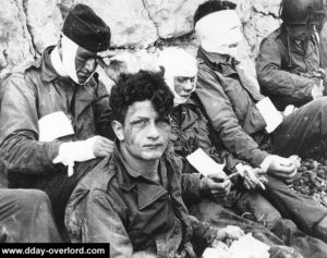 Nid de blessés du 3/16th RCT de la 1ère division d'infanterie installé par le 6th Naval Beach Battalion sur Fox Green à Omaha Beach. Au premier plan : Nicholas Fina de la compagnie I. Photo : US National Archives