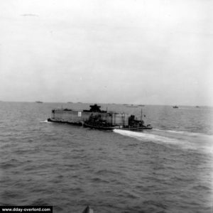 Un caisson Phoenix surmonté d'une tourelle pour canon antiaérien remorqué à travers la Manche. Photo : US National Archives