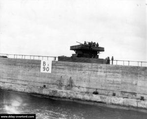 Un caisson Phoenix surmonté d'une tourelle pour canon antiaérien remorqué à travers la Manche. Photo : US National Archives